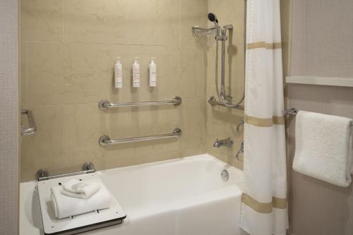 a bathroom with a shower and a bath tub with a sink at San Francisco Marriott Union Square in San Francisco