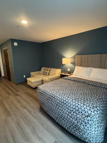 a bedroom with a bed and a chair and a couch at WoodSpring Suites Knoxville - Cedar Bluff in Knoxville