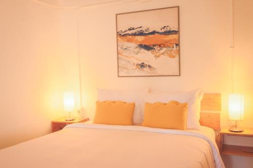 a bedroom with a white bed with two lamps at Alma Vida Hotel in Manuel Antonio