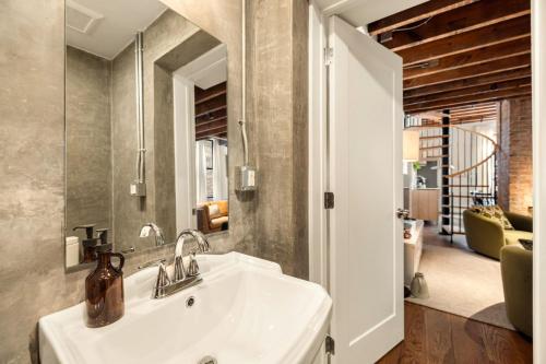 a bathroom with a sink and a mirror at Luxury Loft near Washington Park - Rooftop Deck in Cincinnati