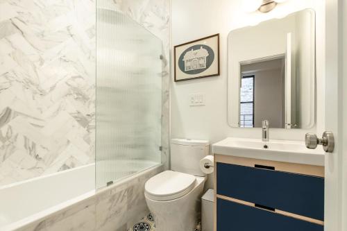 Un baño con inodoro, lavabo y ducha. en Walk to ALL - Washington Park - Gorgeous 2BR Condo, en Cincinnati