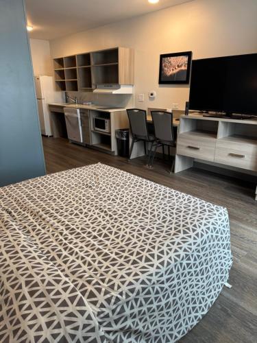 a room with a bed and a desk and a tv at WoodSpring Suites Knoxville - Cedar Bluff in Knoxville