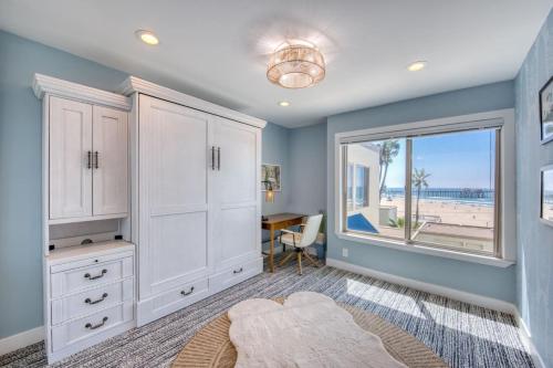 a home office with a large window and a desk at Ocean and Pier View Condo on the Sand in Huntington Beach
