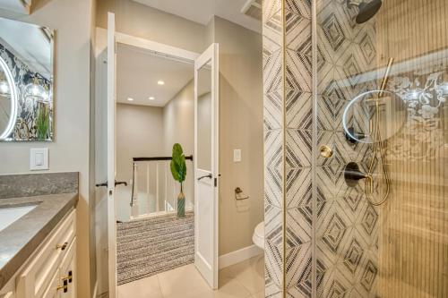 a bathroom with a shower with a mosaic tile wall at Ocean and Pier View Condo on the Sand in Huntington Beach