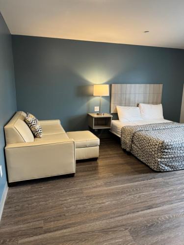 a bedroom with a bed and a couch and a chair at WoodSpring Suites Knoxville - Cedar Bluff in Knoxville