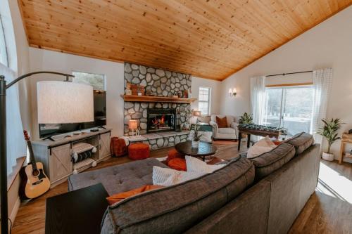 a living room with a couch and a fireplace at Stylish Home with Hot Tub, Ping Pong, Pickleball, Electric Scooters and Pet Friendly in Big Bear City