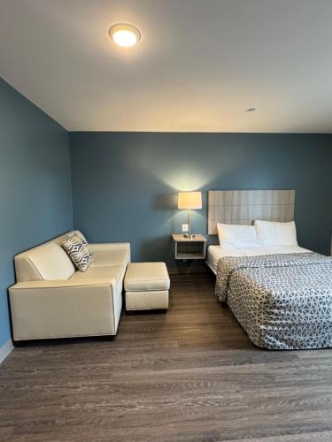 a bedroom with a bed and a couch and a lamp at WoodSpring Suites Knoxville - Cedar Bluff in Knoxville