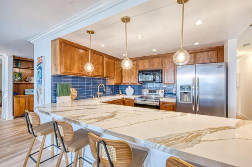 a kitchen with a large island in a kitchen with wooden cabinets at Ocean Harbor View Dana Point in Dana Point