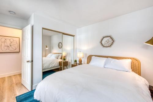 a bedroom with a large white bed and a mirror at Ocean Harbor View Dana Point in Dana Point