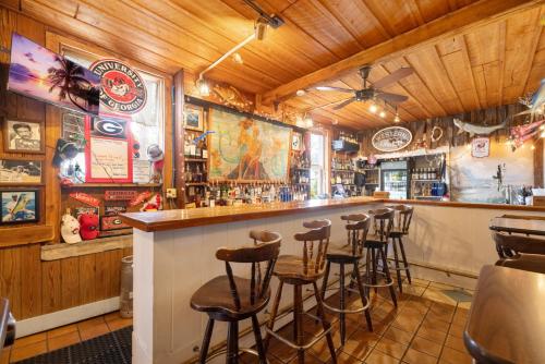 a bar with a row of stools in a restaurant at Cedar Keys Island Hotel in downtown in Cedar Key