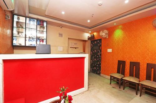 a waiting room with a red counter and chairs at Xpress Inn in Garui