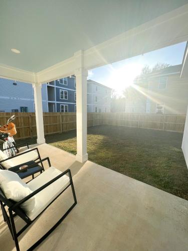 a porch with a bed and a white canopy at Walk to the beach, comes with two bikes, fully fenced in back yard! in Biloxi
