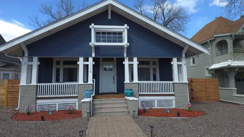 a blue house with a front porch with flowers at Historic Home w/Pikes Peak Views in Colorado Springs