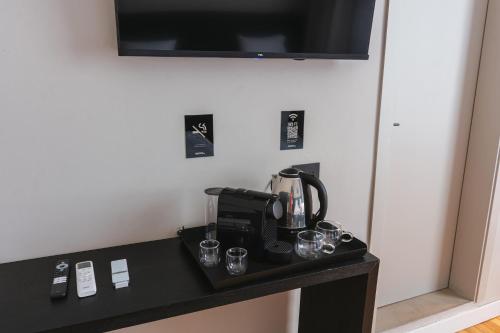 a coffee maker on a table with glasses on it at Main By Babel in Mendoza