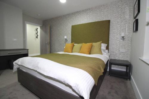 a bedroom with a large bed with yellow pillows at Charming Modern 2br Flat In Central Preston in Preston
