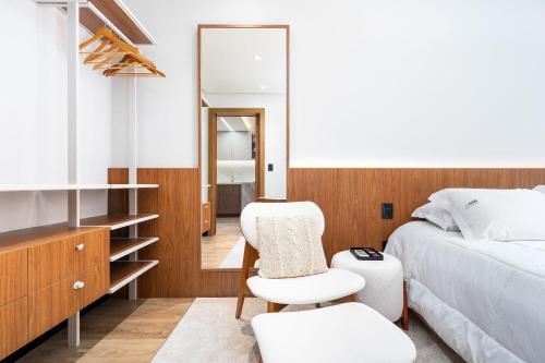 a bedroom with a bed and a mirror at Apartamento Magnólia Piscina Aquecida by Achei in Canela