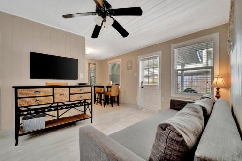 a living room with a couch and a flat screen tv at Stones Throw Beachside Bungalow #1 ON THE BEACH in Clearwater Beach
