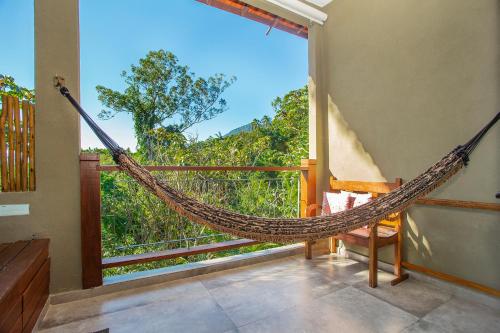 a hammock in a room with a balcony at Hotel Vila Kebaya in Ilhabela
