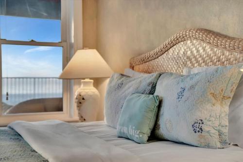 a bed with pillows and a window in a bedroom at Stones Throw Beachfront Family Suite #3 VIEWS in Clearwater Beach
