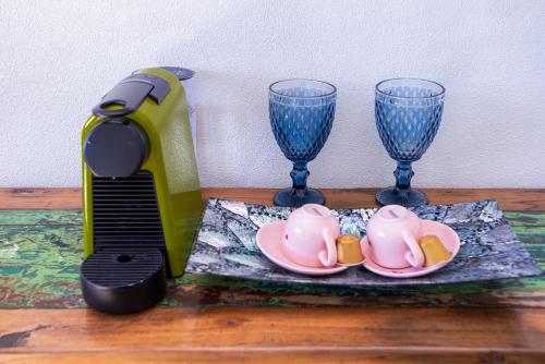 a pair of wine glasses next to a plate and a juicer at Hotel Vila Kebaya in Ilhabela