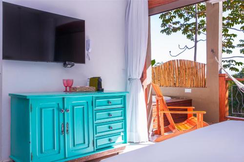 a blue cabinet in a room with a window at Hotel Vila Kebaya in Ilhabela