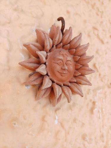 a metal object with a sun head on a wall at Appartamento Sun and Sea in Campora San Giovanni