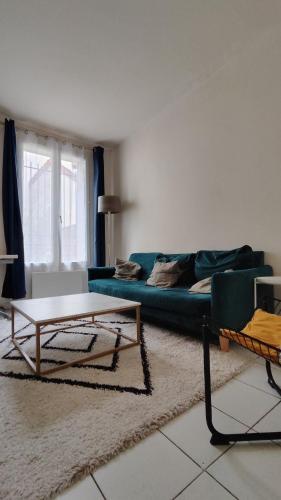 a living room with a blue couch and a table at Modern 1 bedroom apartment near the metro. in Ivry-sur-Seine