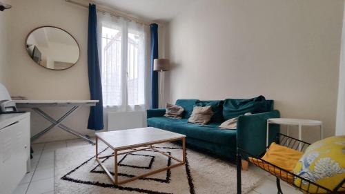 a living room with a green couch and a mirror at Modern 1 bedroom apartment near the metro. in Ivry-sur-Seine