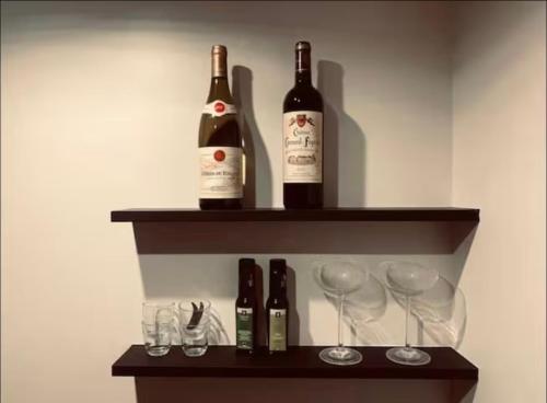 - deux bouteilles de vin assises sur une étagère avec des verres à vin dans l'établissement Chic Studio - Montorgueil, AC & Fast Wi-fi, à Paris