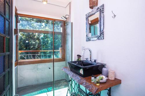 a bathroom with a sink and a glass shower at Hotel Vila Kebaya in Ilhabela