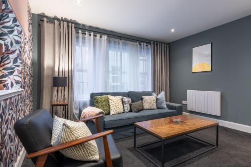 a living room with a blue couch and a table at Ness Central in Inverness