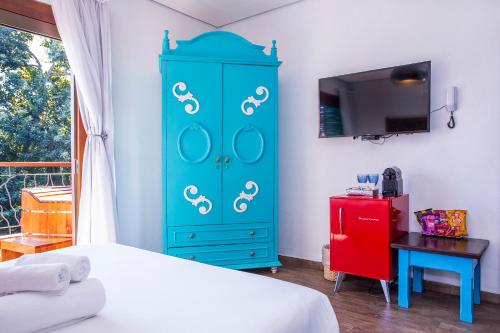 a blue cabinet in a bedroom with a bed at Hotel Vila Kebaya in Ilhabela