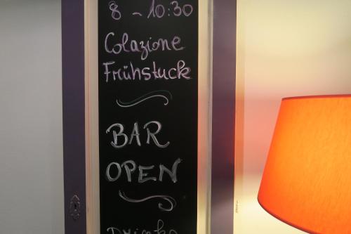 a chalkboard sign that says bar open on a wall at Piccolo Hotel in Locarno