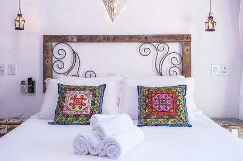 a bedroom with a white bed with towels on it at Hotel Vila Kebaya in Ilhabela