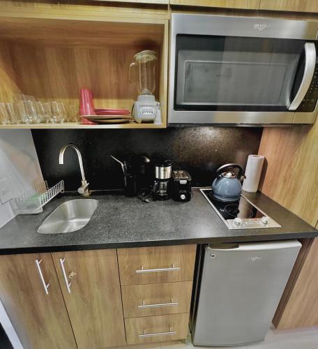 a small kitchen with a sink and a microwave at LIFE Bucerias Zona Dorada Tranquil Beach Loft in Bucerías