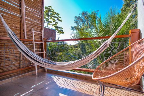 a hammock on a porch with a fence at Hotel Vila Kebaya in Ilhabela