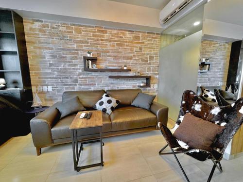 a living room with a couch and a brick wall at LIFE Bucerias Zona Dorada Tranquil Beach Loft in Bucerías