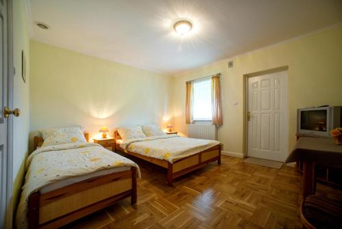 1 Schlafzimmer mit 2 Betten, einem TV und einem Fenster in der Unterkunft Pensjonat Eskapada in Polańczyk