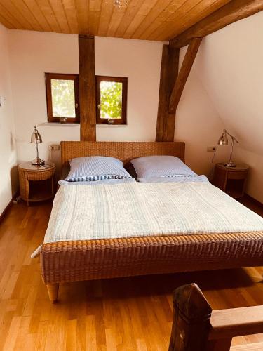 a large bed in a room with two windows at Ferienwohnungen auf einem ehemaligen Bauernhof in Neuhausen