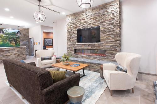 a living room with two couches and a fireplace at La Quinta Inn and Suites by Wyndham Lincoln in Lincoln