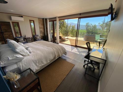 a bedroom with a bed and a view of a patio at Nidos de Apalta in Santa Cruz