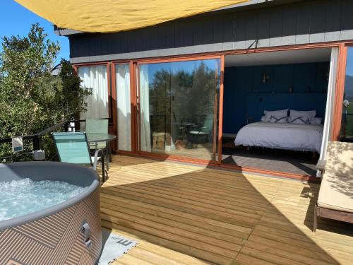 a room with a bed and a tub on a deck at Nidos de Apalta in Santa Cruz