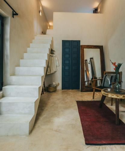 a staircase in a room with a rug and a table at Yum Kaax Boutique Villa in Tulum