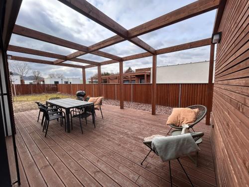 a patio with a table and chairs on a deck at Rezidence Strachotín in Strachotín