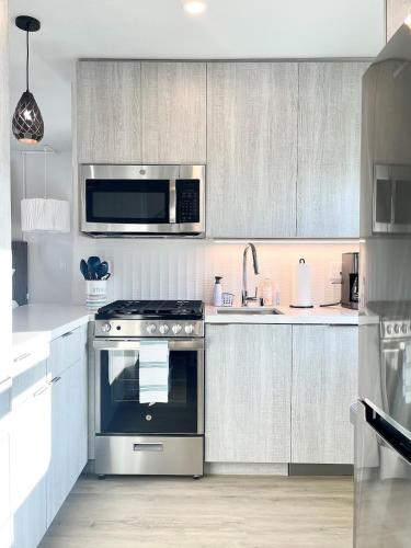 a kitchen with a stove and a microwave at Stunning Ocean Beach Gem - has everything! in San Diego