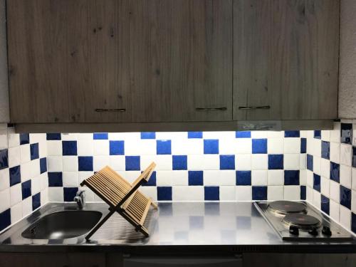 韦尔科尔地区科尔朗松Résidence La Grande Traversee - Charmant studio pied des pistes MAE-3824的厨房柜台设有水槽和蓝色及白色瓷砖