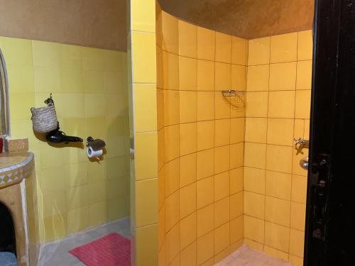 a bathroom with a shower with yellow tiles at Riad Syba in Marrakech