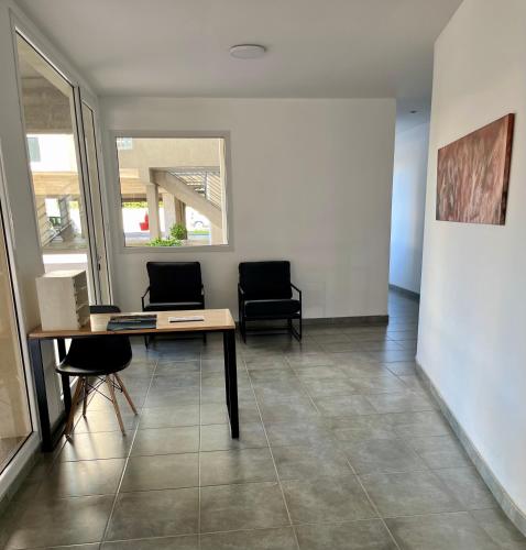 a living room with two chairs and a table at Monoambiente Muñíz in Luján