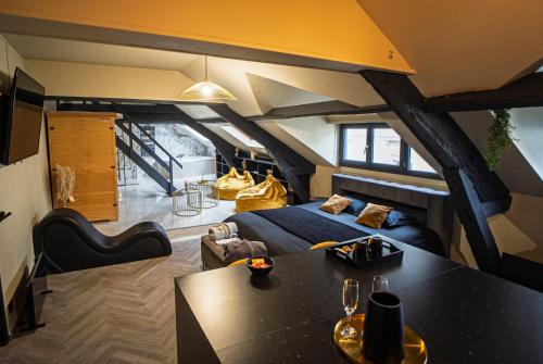 an attic room with a bed and a table at La Marble Room - Suite balnéo & sauna in Angers