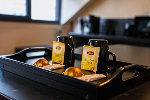 a tray with two hot dogs and bottles of mustard at La Marble Room - Suite balnéo & sauna in Angers